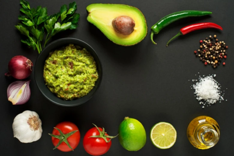 Suroviny na guacamole: avokádo, rajčata, citrony, cibule, česnek, bylinky.