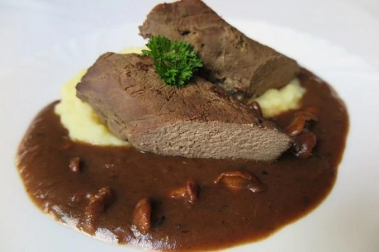Dva kusy srnčího masa s houbami na bramborovém pyru.