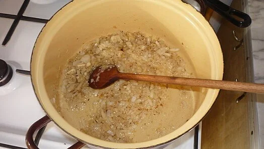 Smažené cibulka v hrnci na vaření guláše.