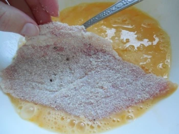 Kousek masa v mouce se máčí do vejcové směsi.