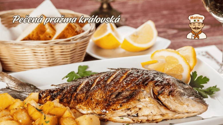 Pečená ryba s bramborami a citronem na bílém talíři.