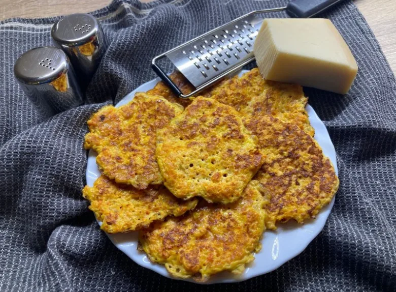 Příprava mrkvových placků s tvrdým sýrem na talíři.