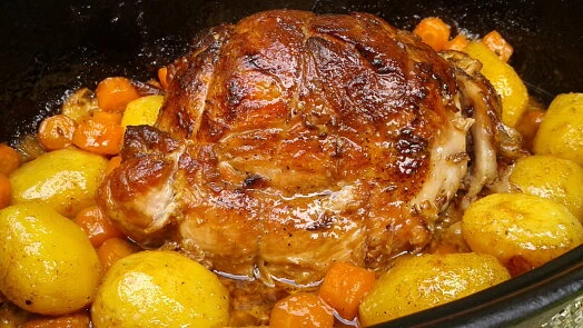 Pečené vepřové maso s bramborami a kořenovou zeleninou.