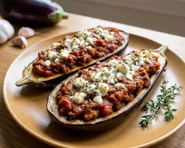 Stuffed eggplant halves with sauce and cheese
