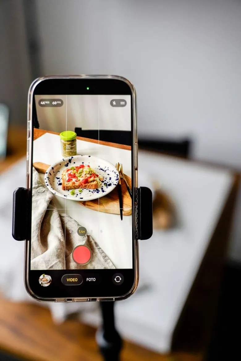 Smartfon s aplikací fotoaparátu ukazující zapečený tost na talíři.