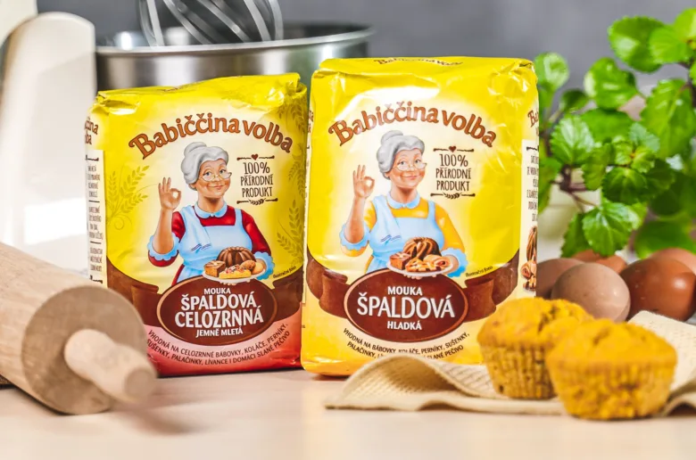 Balíčky špaldové mouky s vejci a kynutými muffiny na kuchyňské desce.