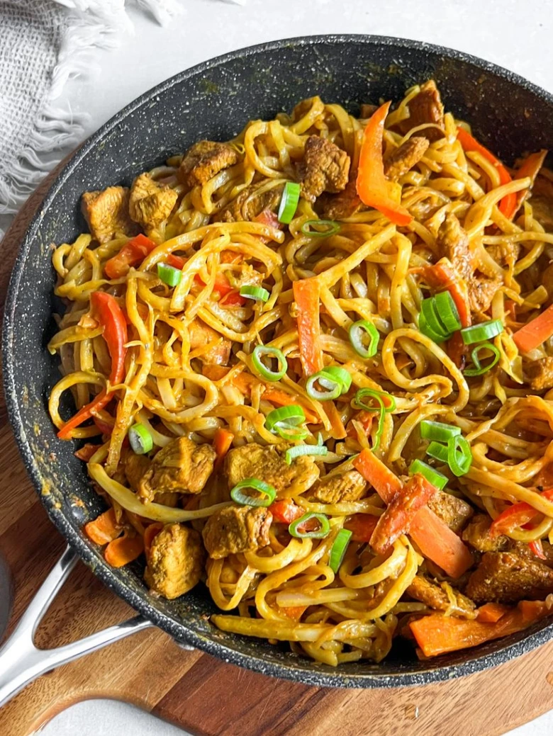 Udon nudle s masem a zeleninou v pánvi po vaření.
