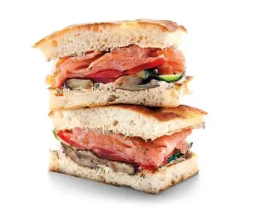 Sandwich s lososem gravlaxem se zeleninou na chlebu.