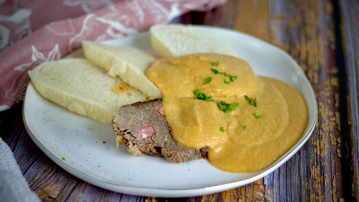 Připravená falešná svíčková s omáčkou na talíři.