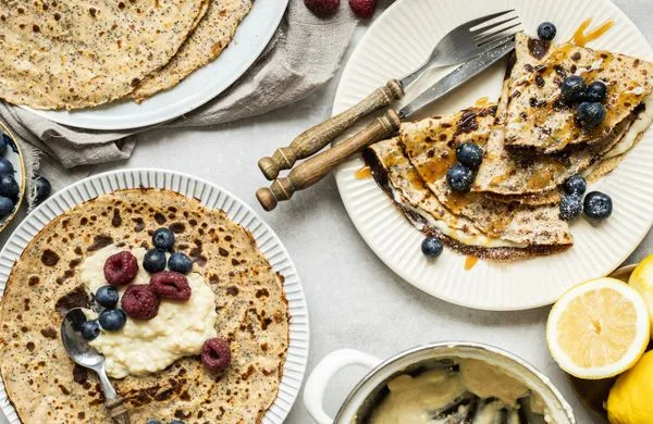Palačinky ze špaldové mouky s borůvkami a malinami na talíři.