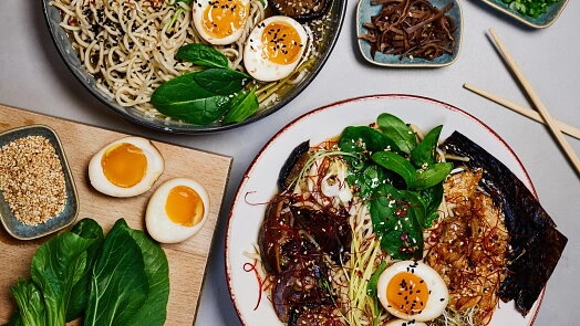 Dva talíře s japonskou polévkou ramen se vejci a zeleninou.