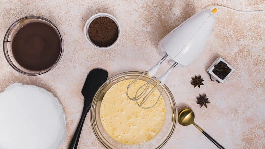 Suroviny na dort Pavlova s čokoládou a cukrem v misce.