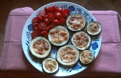 Pečené cukety s mozzarellou a rajčaty na talíři.