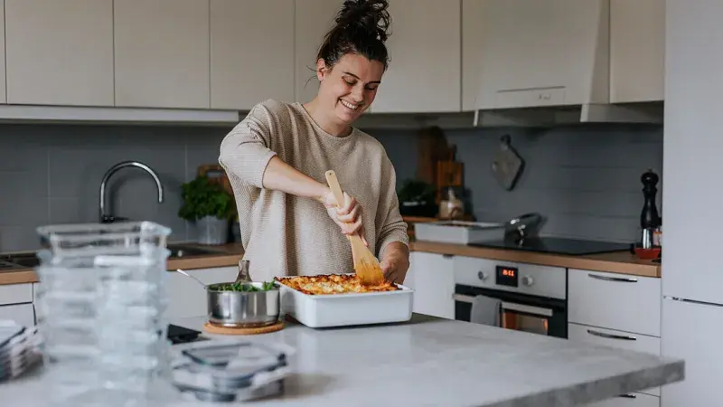 Žena vaří rychlou večeři v kuchyni.