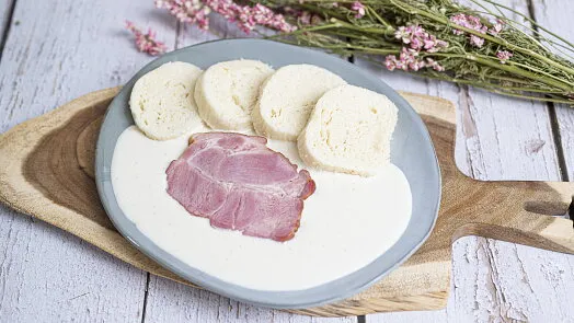 Připravené šunkofleky s chlebem a omáčkou na talíři.